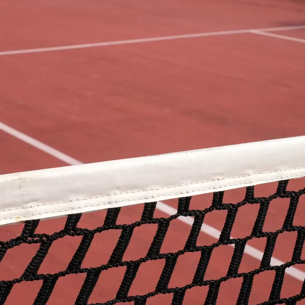 Tennisnetz auf einem roten Sandplatz.