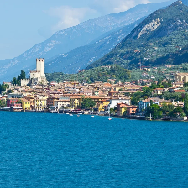 Vista panoramica del borgo di Malcesine sul Lago di Garda con le montagne sullo sfondo.