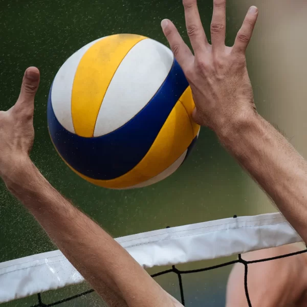 Volleyballspiel mit einem Ball, der über das Netz kommt.