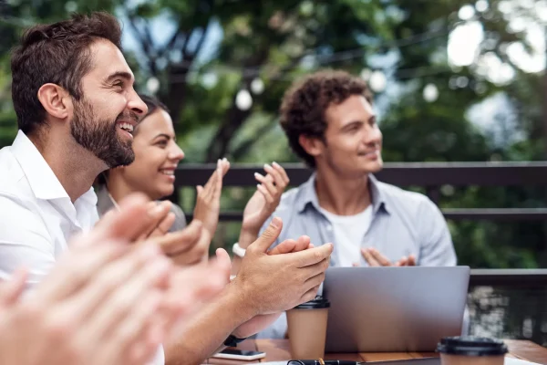 Persone che applaudono all'aperto durante una riunione informale.